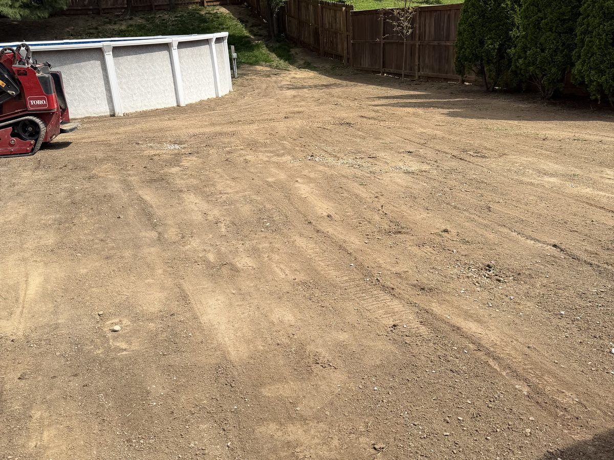 Uneven backyard with bare patches before leveling and sod